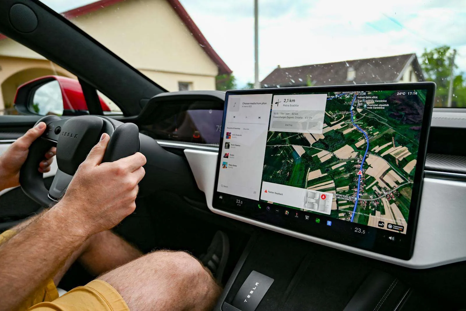 Tesla electric vehicle dashboard showing GPS navigation on a large touchscreen infotainment display